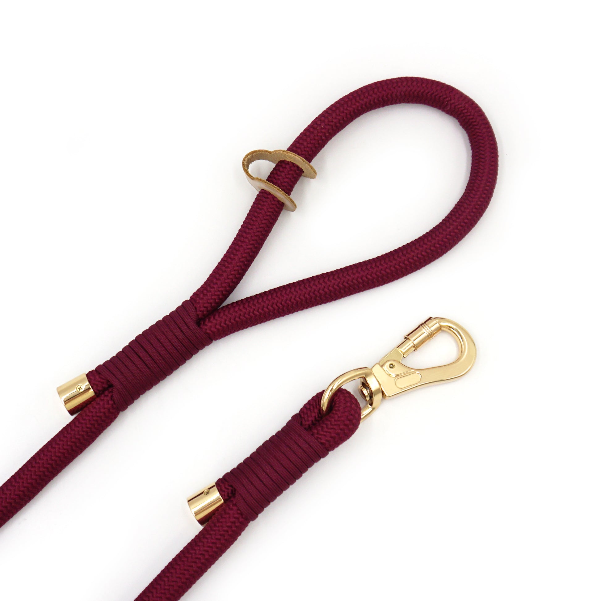 Maroon dog leash with gold carabiner hardware on a white background