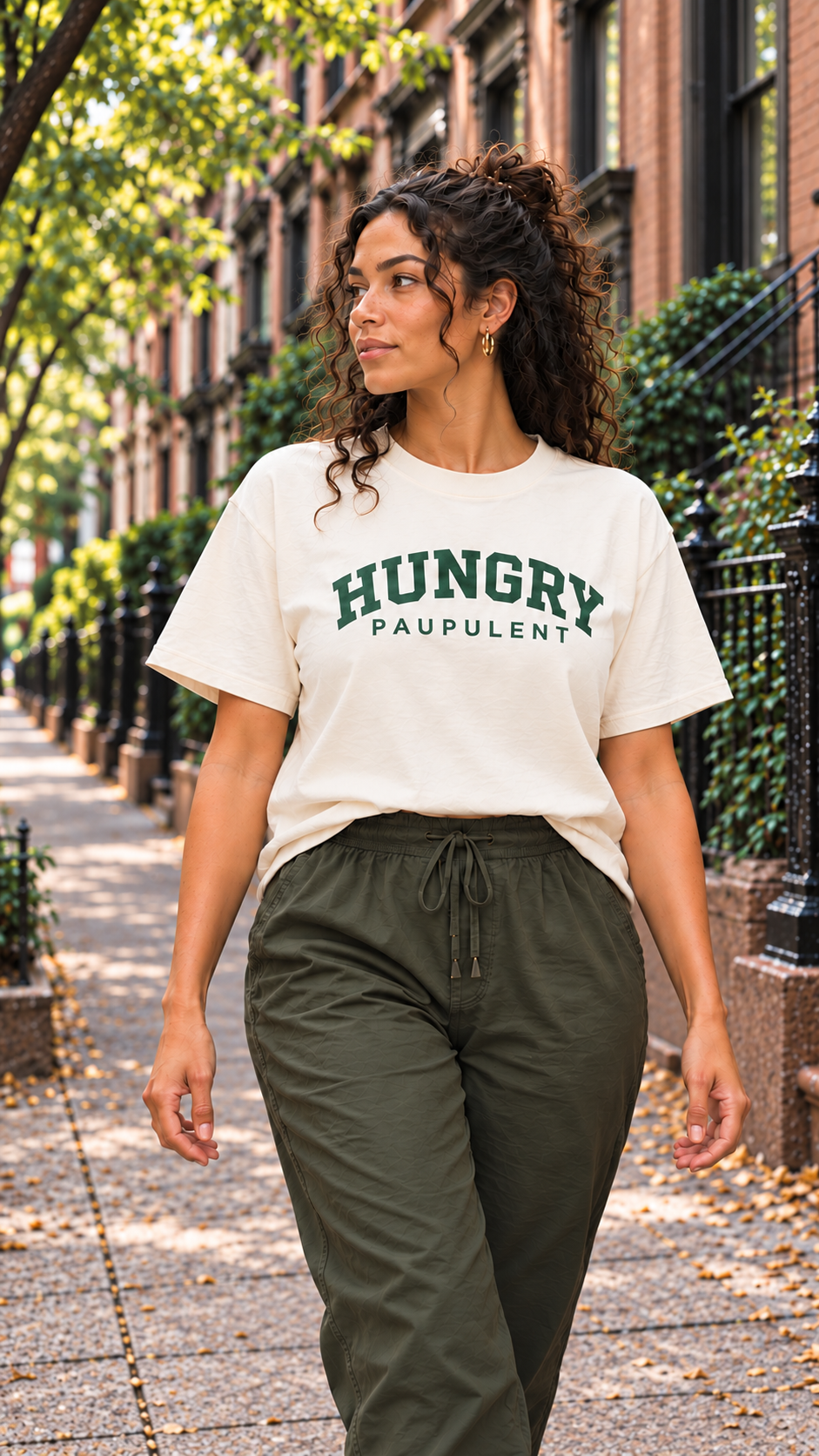 Woman walking down a brownstone street in the ivory HUNGRY tee
